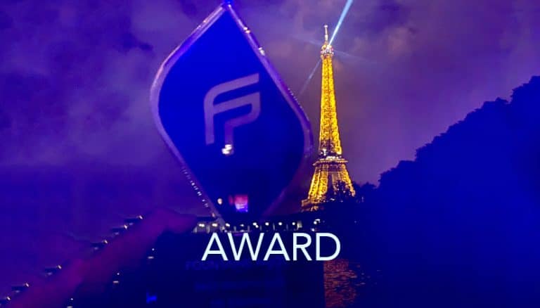 A person holds an award with a stylized "F" logo against a backdrop of the illuminated Eiffel Tower at night. The word "AWARD" is visible on the trophy, presented for Best Growth, and a bright beam of light can be seen in the sky.